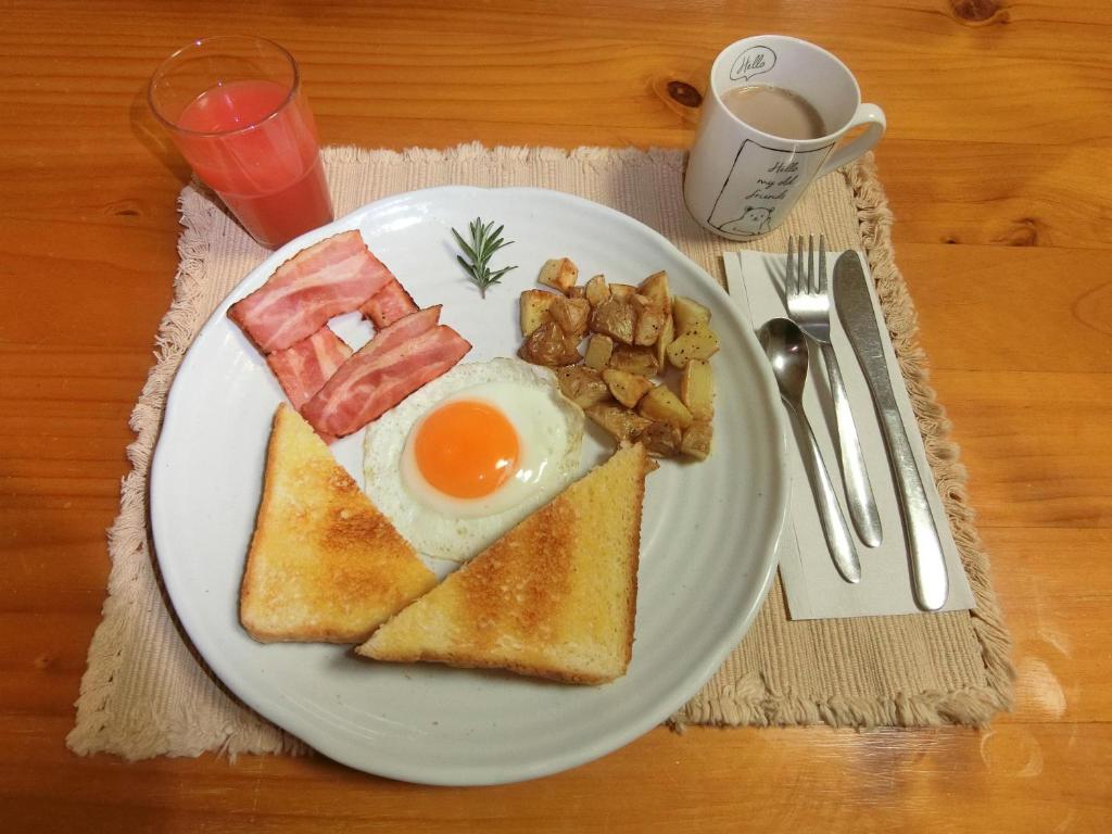 a plate of breakfast food with eggs bacon and toast at Shirokuma Inn in Toyama