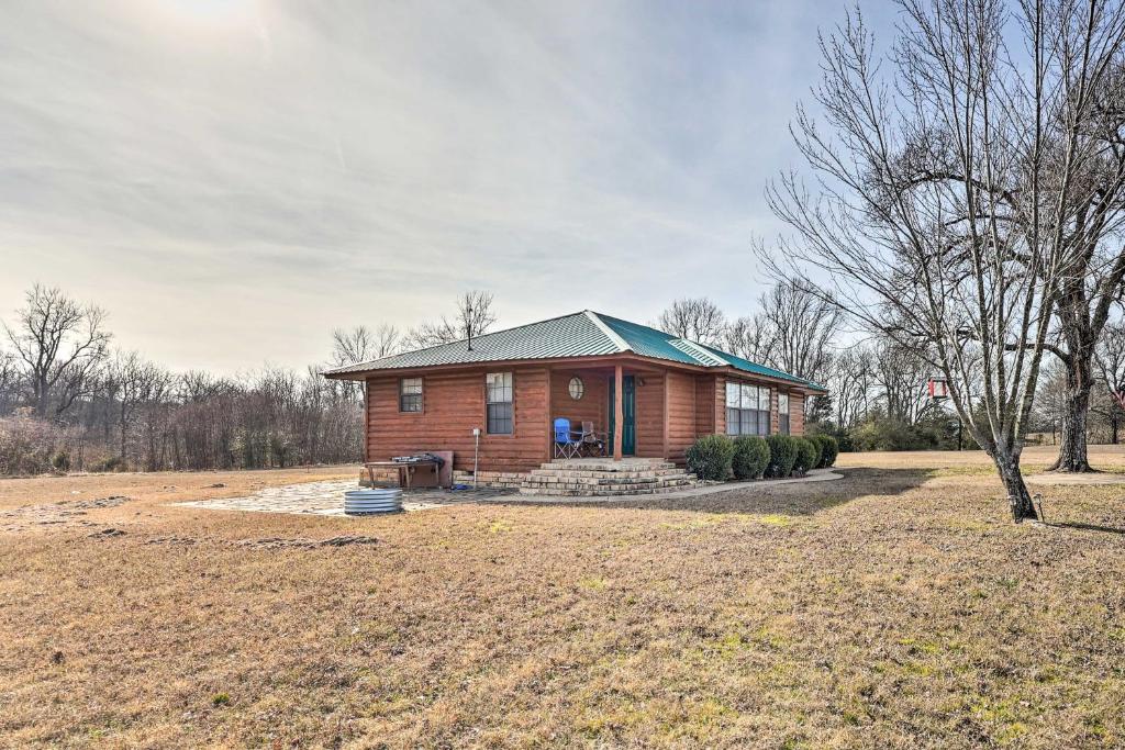 una pequeña casa de madera con techo verde en Pet-Friendly Cabin Rental Retreat! 