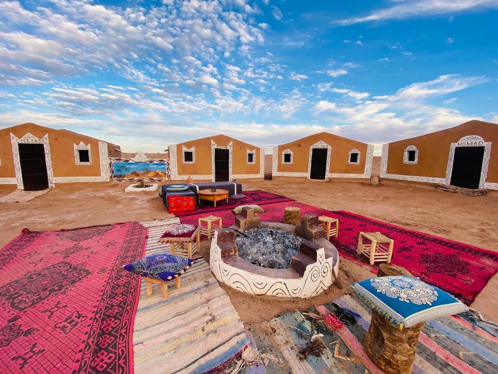 una zona giorno di un campo con buca per il fuoco di Desert Tours & Camp Chraika a M'Hamid