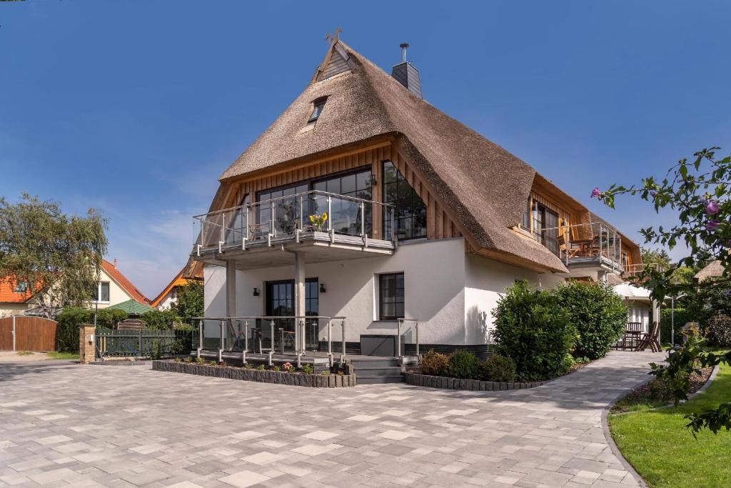 a house with a thatched roof with a patio at Ostsee Domizil Graal-Müritz in Graal-Müritz