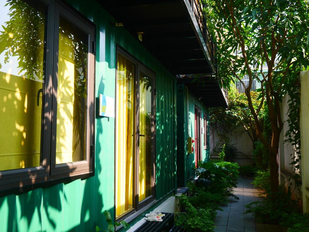 海防的住宿－Cửa Biển Homestay，绿色建筑的侧面设有窗户