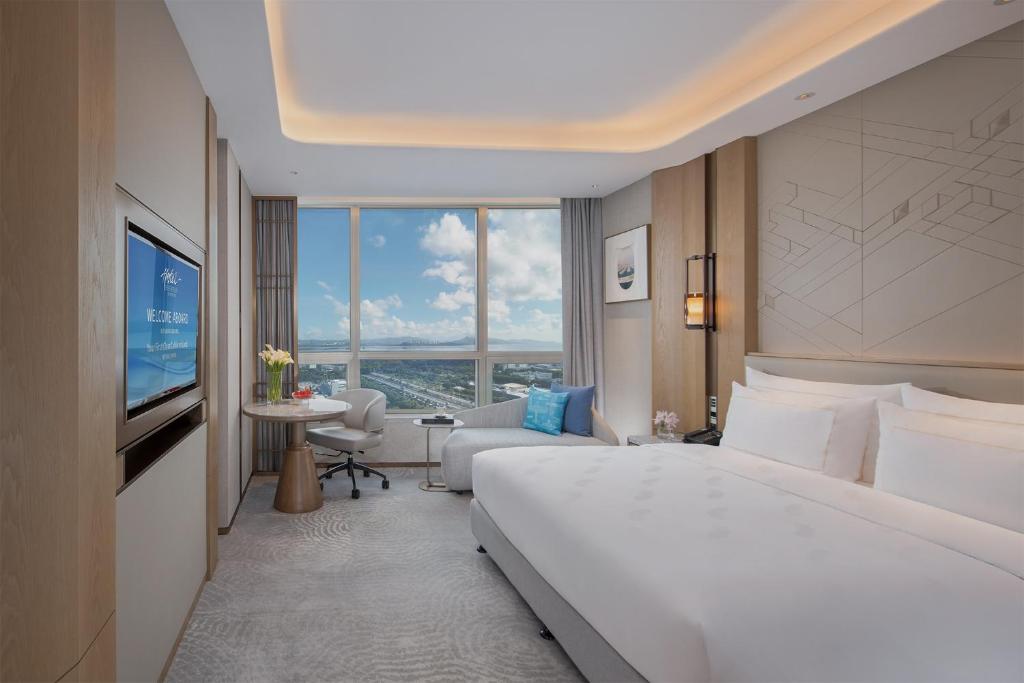 a hotel room with a large bed and a large window at Shenzhenair International Hotel in Shenzhen