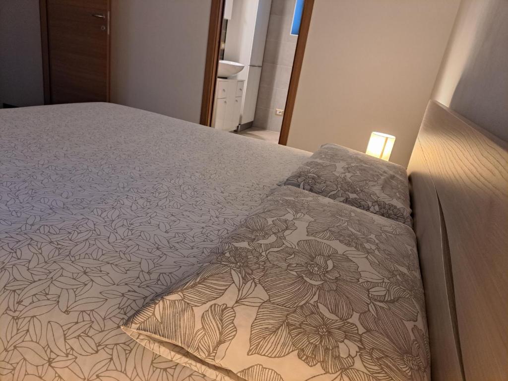 a bedroom with a bed with a flower pattern on it at RESIDENZA CADORINA in Calalzo