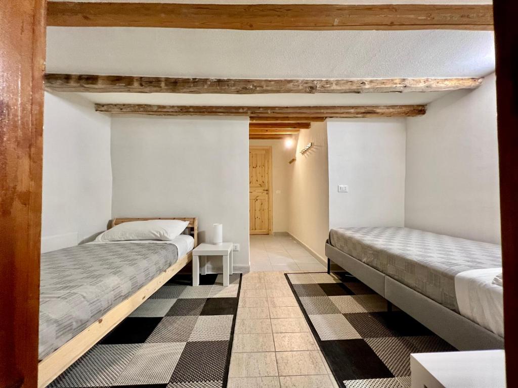two beds in a room with a checkered floor at Castello a Mare in Castellammare del Golfo