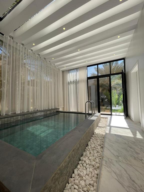 a swimming pool in a house with a large window at MY HOTEL Al Lathba Pool Villa - Nizwa فيلا اللثبه-نزوى in Nizwa