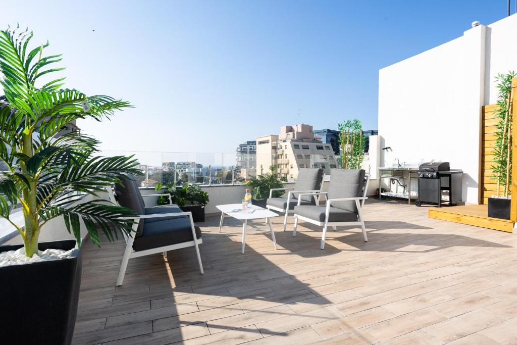 a patio with chairs and a table on a roof at YalaRent Flora- Designed 1BR penthouse in Florentin in Tel Aviv