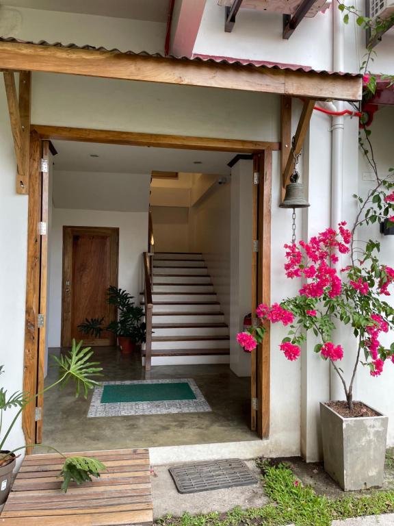 una entrada a una casa con flores rosas en P&B Residences Legazpi, en Legazpi