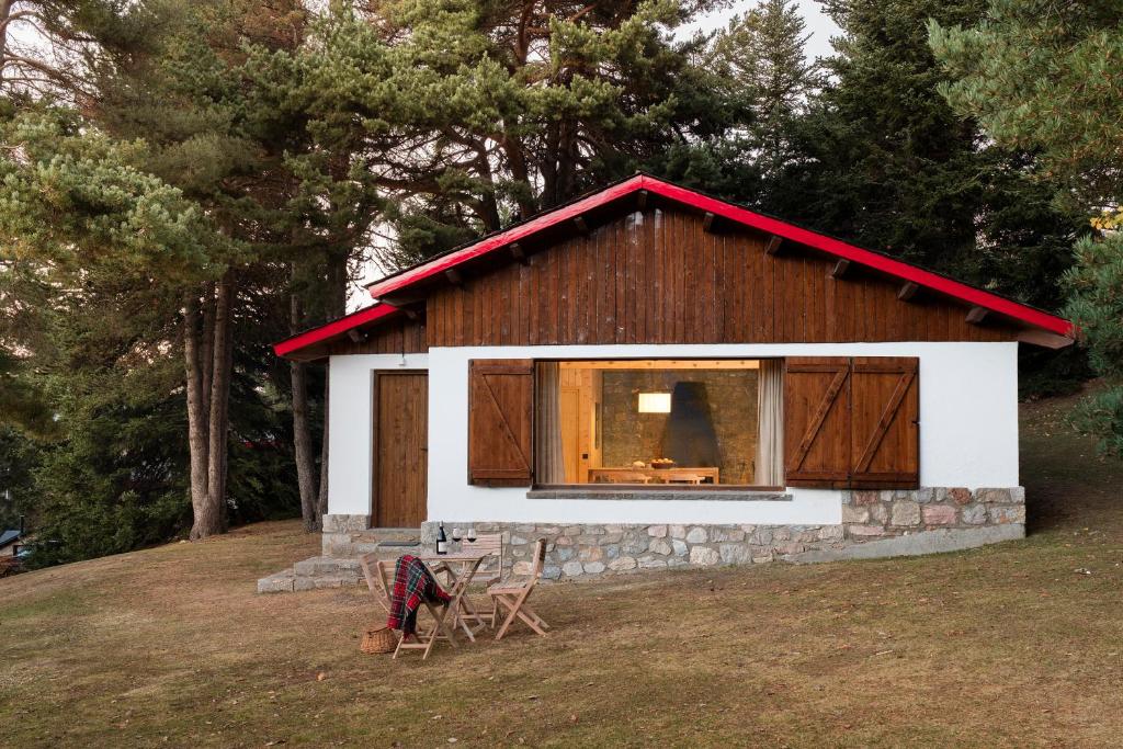 a small house with a red roof on a field at Chalet en la motaña in La Molina
