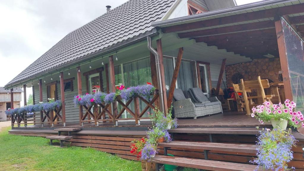 una casa con flores en el porche delantero en ZARIŅI, en Krāslava