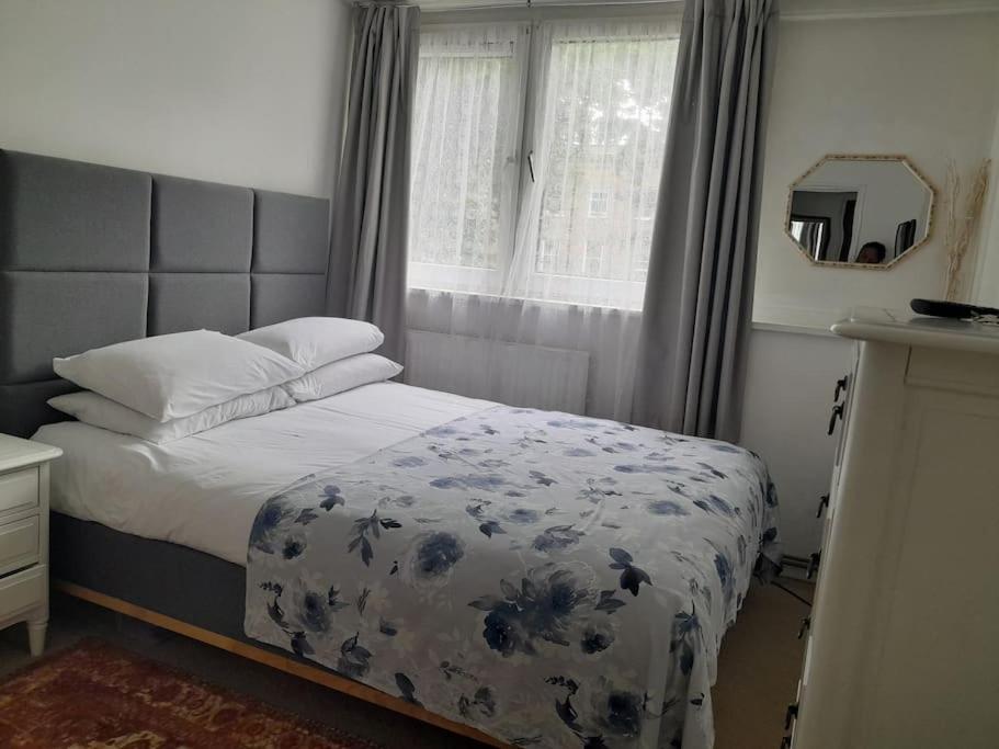 a bedroom with a bed with a blue and white blanket at Room in Camden with Queen Size Bed for Non Smoking Females only in London