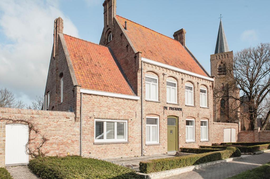 ein altes Backsteingebäude mit orangefarbenem Dach in der Unterkunft De Pastorie Diksmuide in Diksmuide