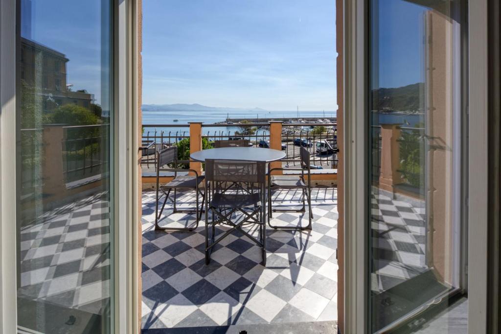 a balcony with a table and chairs and a view of the ocean at Residence Via Di Francia in Arenzano