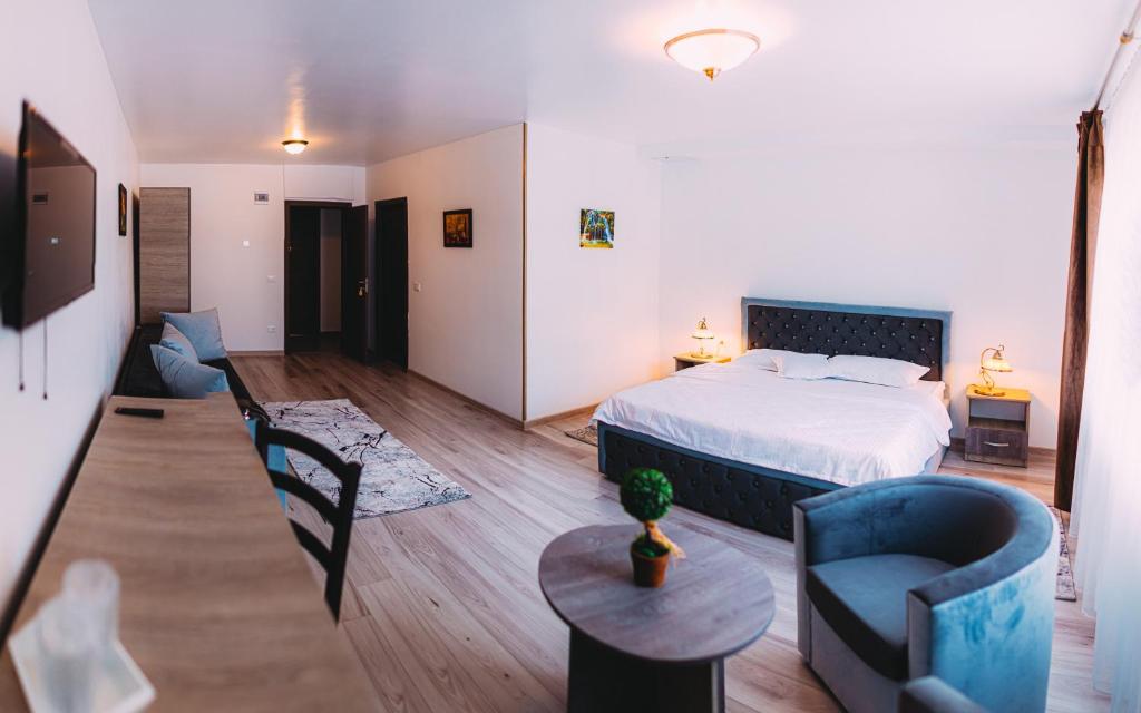 比卡茲的住宿－Motel Piatra Corbului，卧室配有一张床和一张桌子及椅子