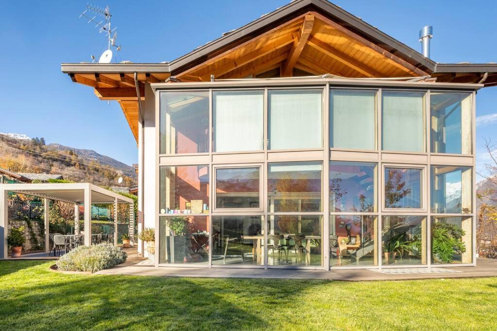 a house with large glass windows on a lawn at B&B Ambrosia in Aosta