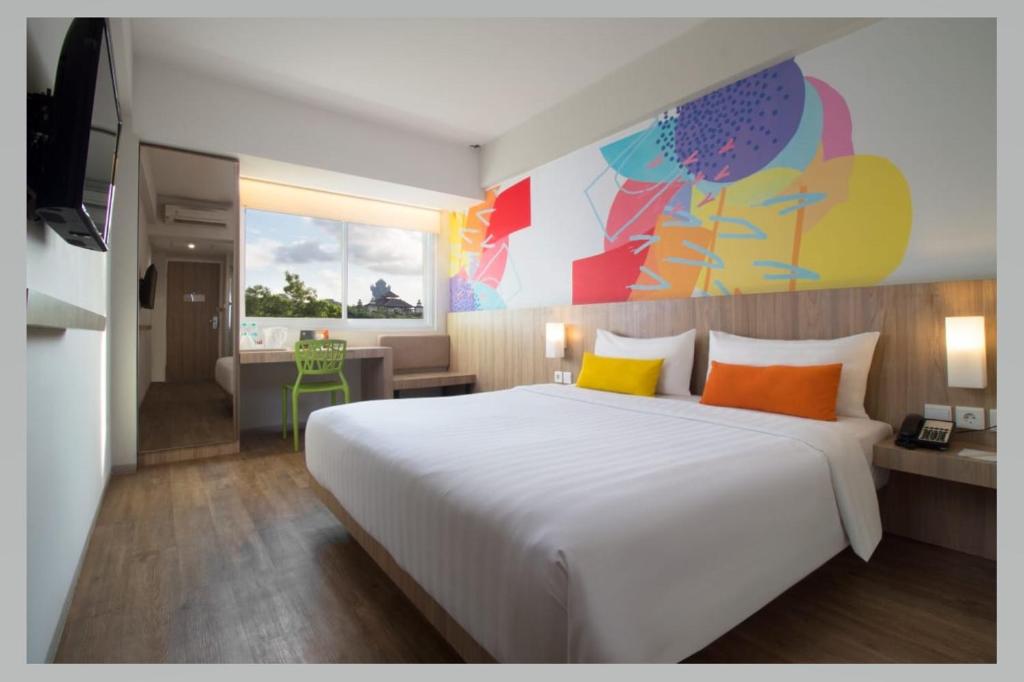 ジンバランにあるZuri Express Jimbaranのベッドルーム1室(大きな白いベッド1台、オレンジと黄色の枕付)
