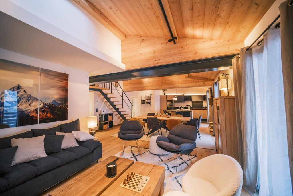 a living room with a couch and chairs and a table at Loft Zodiak -Centre Ville , 5 Chambres+ Vue in Les Houches