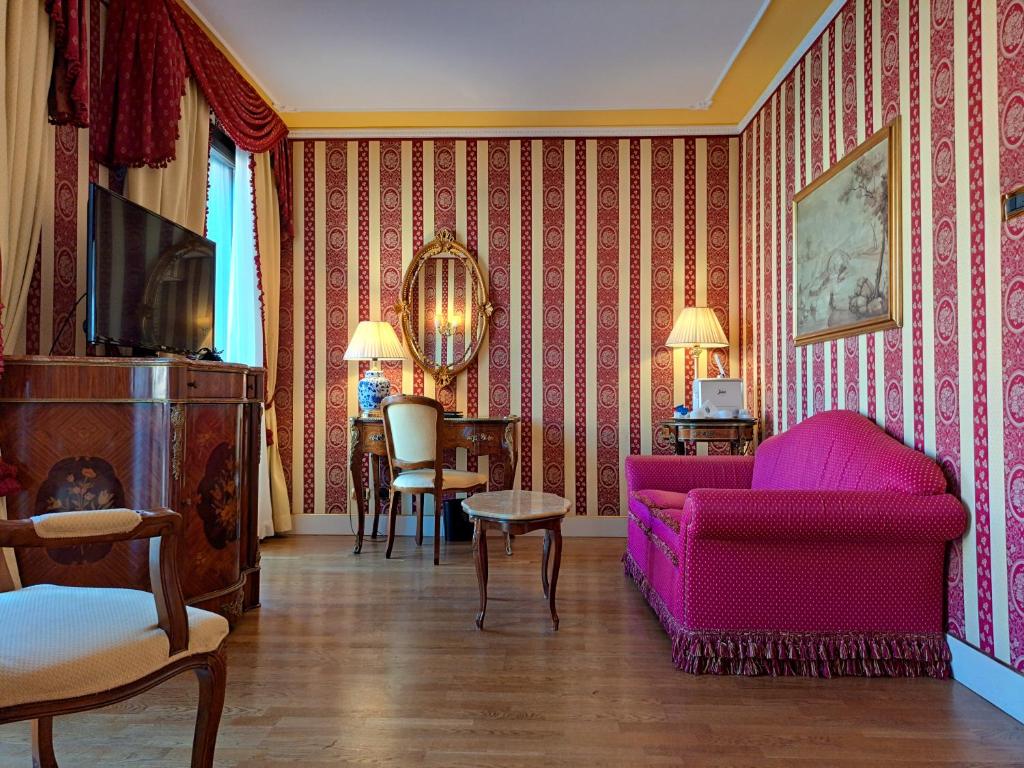a living room with a pink couch and chairs at Sina Palazzo Sant'Angelo in Venice
