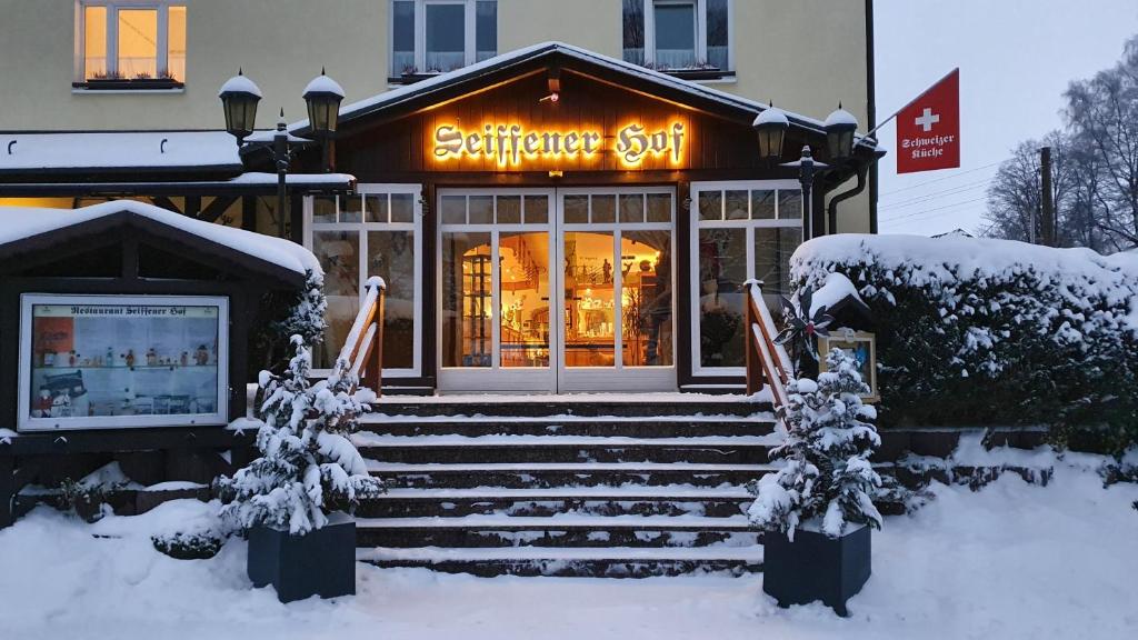 una tienda con un cartel en la nieve en Hotel Seiffener Hof***, en Seiffen