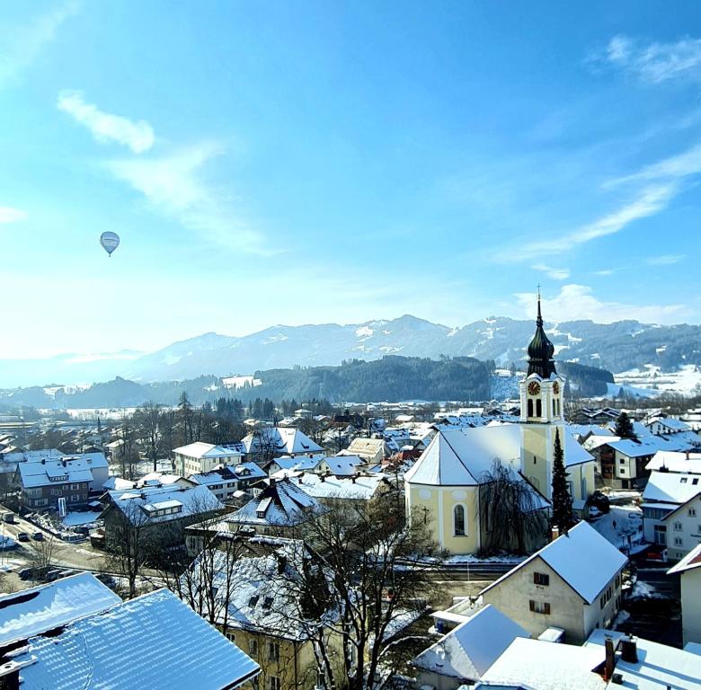 a small town with snow covered roofs and a church at Sanosueno in Sonthofen