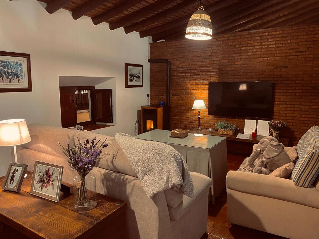 sala de estar con sofá y TV en Apartamentos San José, en Zafra