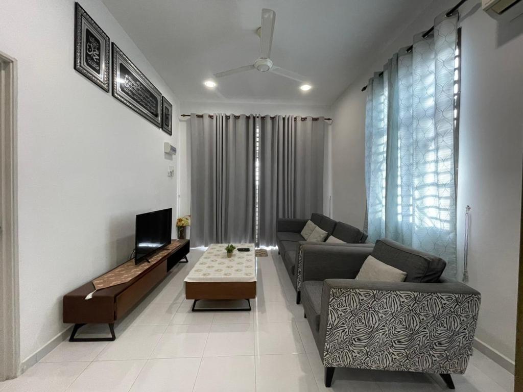 ein Wohnzimmer mit einem Sofa und einem Tisch in der Unterkunft RB HOMESTAY in Merlimau