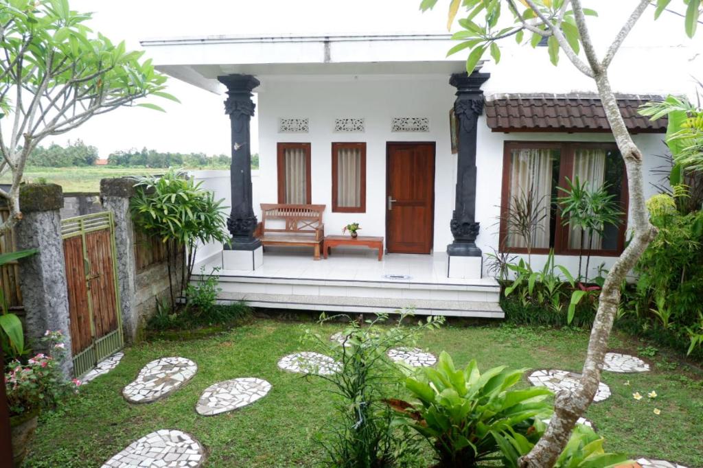 a house with a bench on the front yard at Karauci Homestay in Abeansemal