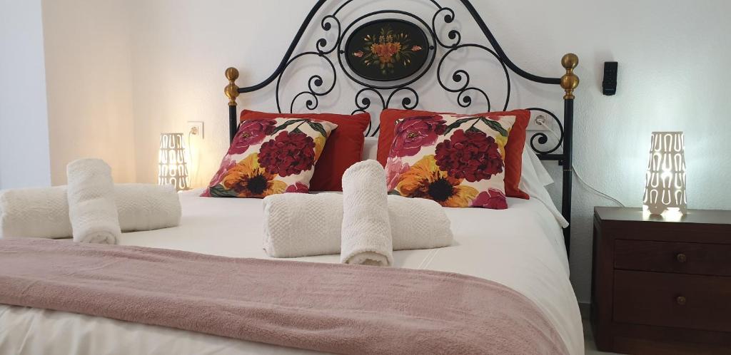 a bedroom with a large bed with red pillows at Apartamentos Maria Cristina in Córdoba