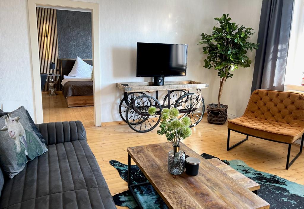 - un salon avec un canapé et une télévision sur une table dans l'établissement 4 SEASON LODGE, à Zell am See