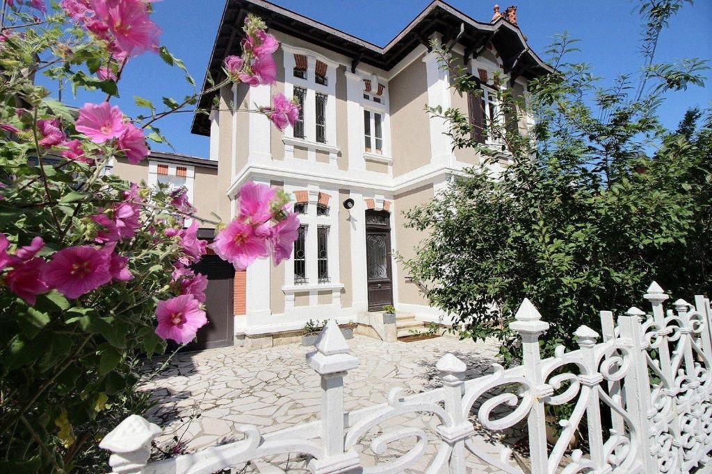 une clôture blanche devant une maison avec des fleurs roses dans l'établissement Arcachon-centre belle maison 5 chambres proche des plages à pieds, à Arcachon