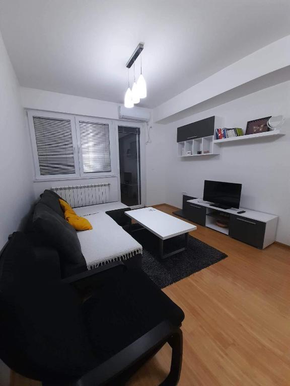 een woonkamer met een bank en een tafel bij Astrid Apartment in Skopje