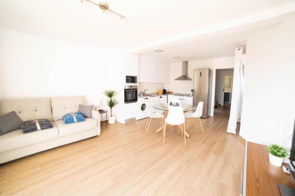 a living room with a white couch and a table at ATICO CENTRO GANDIA in Gandía