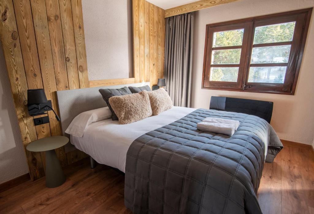 um quarto com uma cama grande e uma janela em Borda Conangle Mountain Lodge em Sant Julià de Lòria