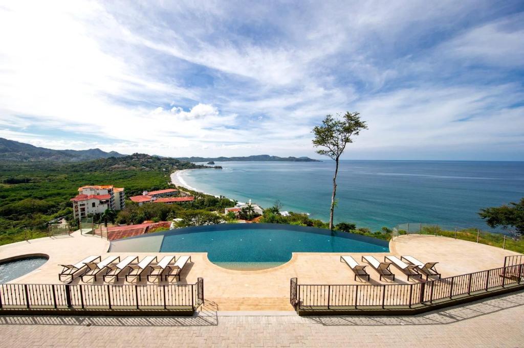 - une piscine avec des chaises et une vue sur l'océan dans l'établissement 360 Splendor 104A-Ocean View 2 Br Condo-Breakfast Included!, à Playa Flamingo
