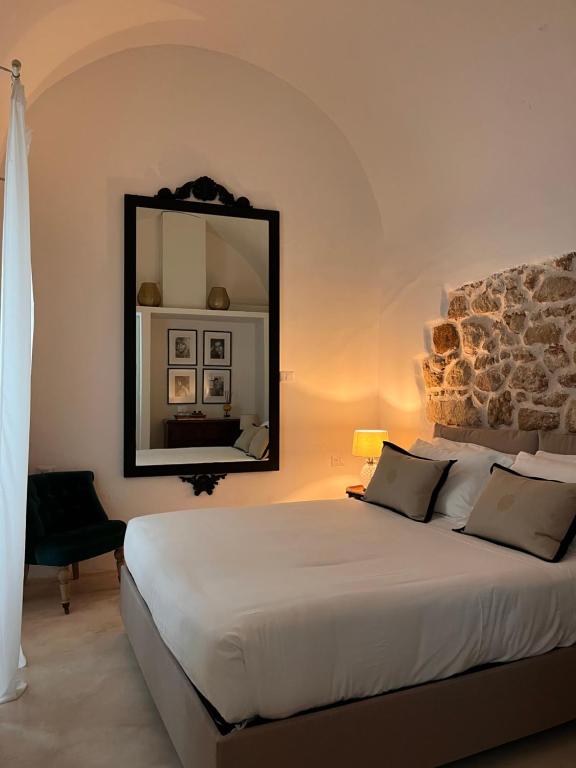 ein Schlafzimmer mit einem großen Bett und einem Spiegel in der Unterkunft Agata Salento Luxury Home in Matino