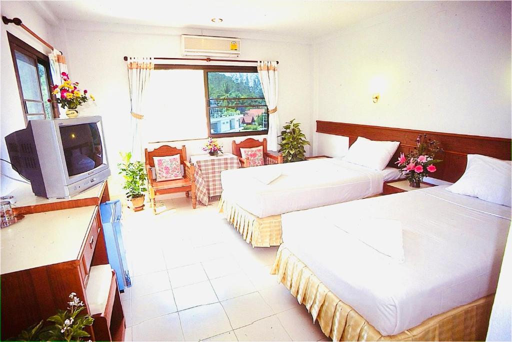 Habitación de hotel con 2 camas y TV en J Mansion en Ao Nang
