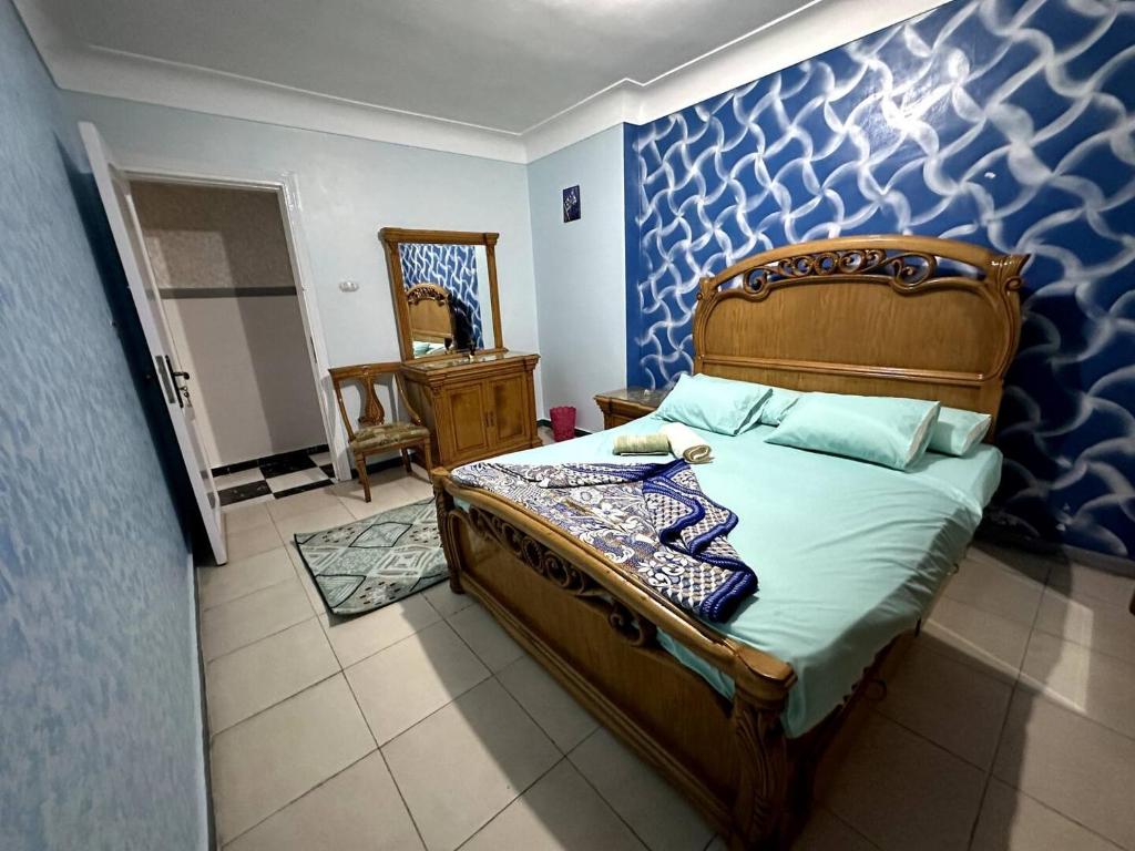 1 dormitorio con 1 cama con pared azul en Appartement à Miami - Vu sur mer en Alexandria