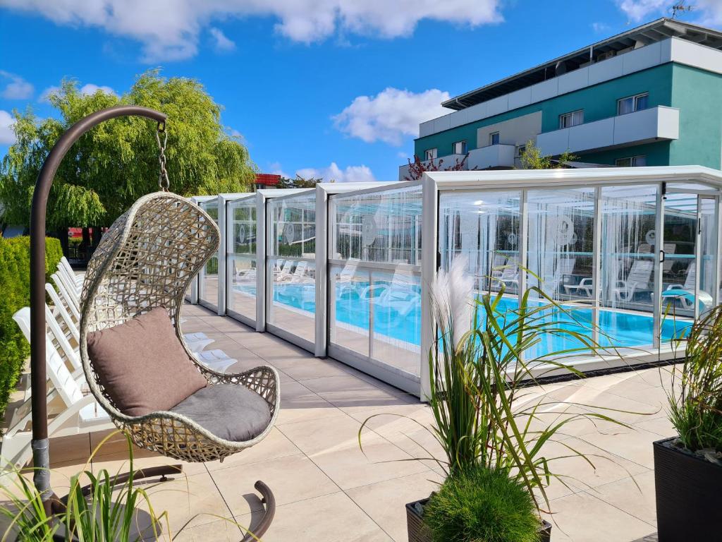 a swinging chair in front of a swimming pool at Ośrodek Sea Star Premium in Sarbinowo