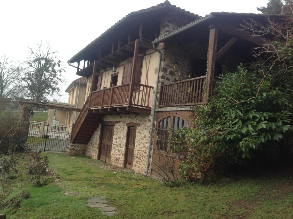 una casa con un balcón en el lateral. en superbe petite maison de caractère dans le Cantal, en Maurs