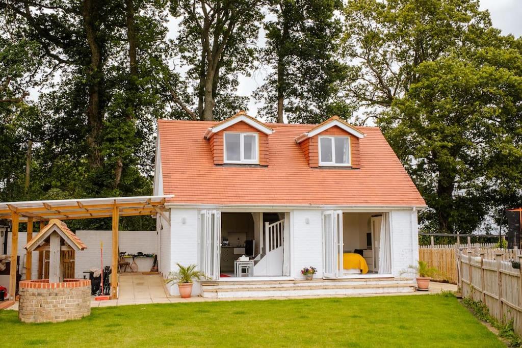 a small white house with an orange roof at Blackberry Annex. Detached cottage. Rural location in West Chiltington