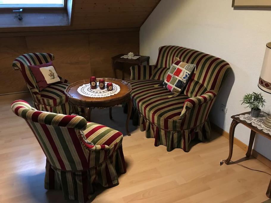 sala de estar con 2 sillas y mesa en 2-room-apartment with shared garden place and view on nature reserve en Brügg