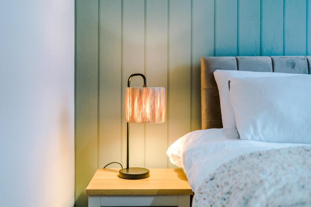 a lamp on a night stand next to a bed at Trendy house, close to stadiums, free wifi and car park in Liverpool