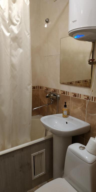 a bathroom with a sink and a toilet and a tub at Nocturne Apartment in Chişinău