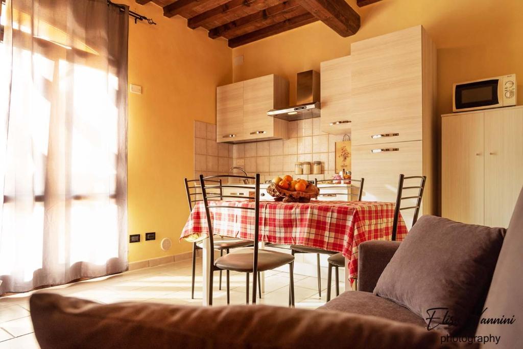 una cocina con mesa y sillas con mesa y una habitación en Appartamento Sole-Luna, en Colleoli