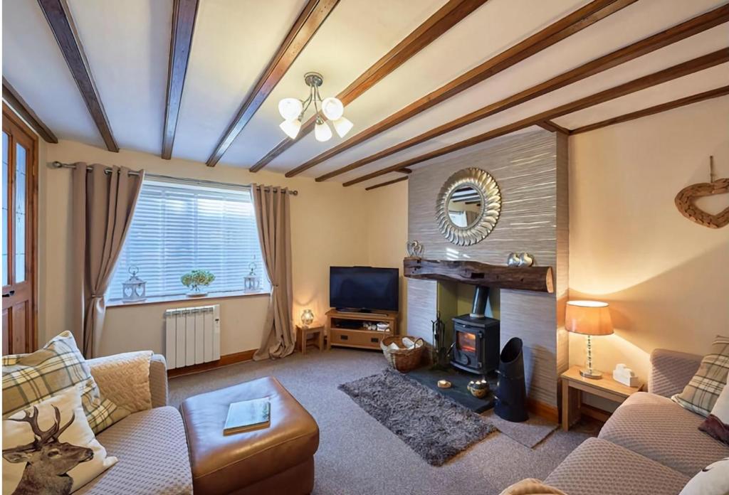 a living room with a couch and a fireplace at Cosy Cumbrian cottage for your country escape in Brough