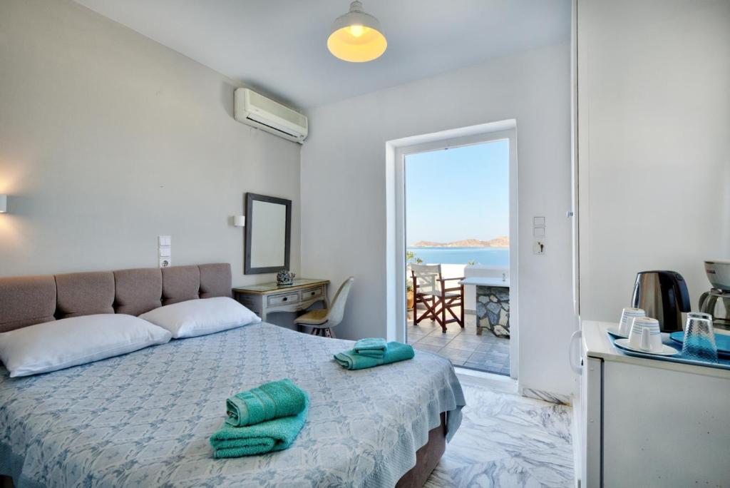 a bedroom with a bed and a view of the ocean at Irene Rooms Naousa Parou in Naousa