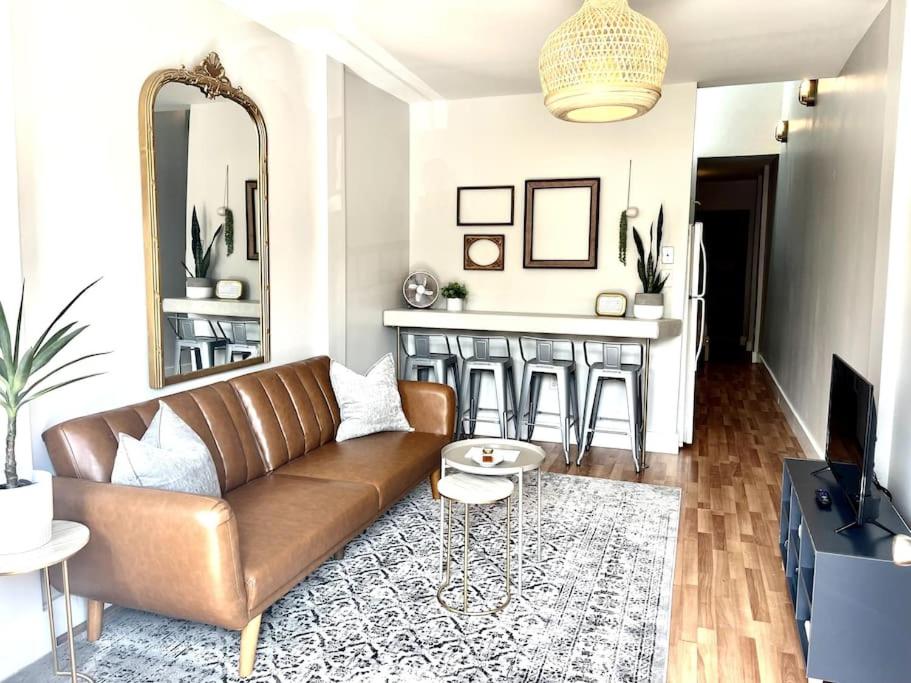 a living room with a brown couch and a mirror at Great Apartment in WeHo in Nashville