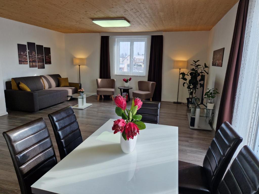 ein Wohnzimmer mit einem weißen Tisch mit Blumen darauf in der Unterkunft Apartment St. Pölten in Sankt Pölten