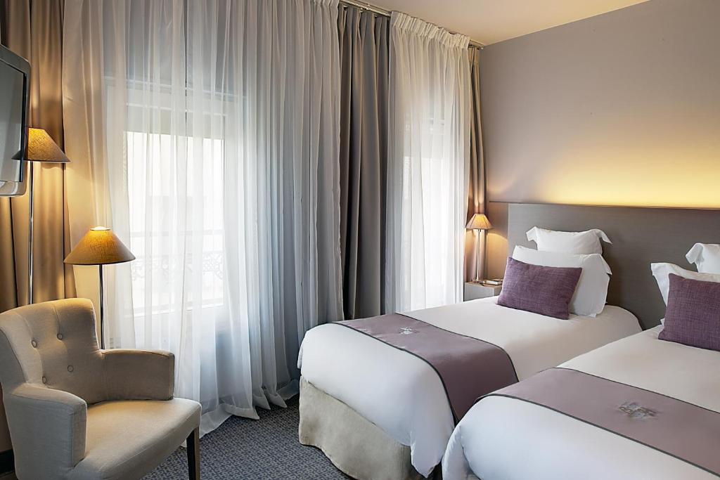 a hotel room with two beds and a chair and a window at Best Western Hotel de la Breche in Niort