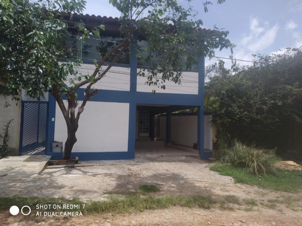 un edificio azul y blanco con un árbol delante en Casas do Rodrigo en Santana do Riacho