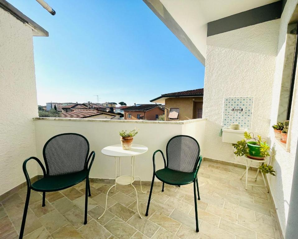 un patio con 2 sedie e un tavolo sul balcone di Appartamento Gemma a Pietrasanta